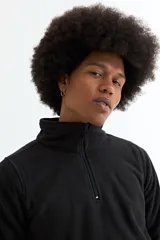 Buzo de polar gris con cuello alto y cierre frontal parcial, de manga larga y ajuste cómodo.