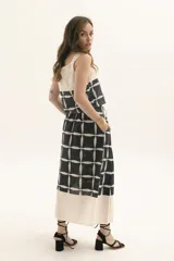 Top de tirantes anchos con diseño bicolor, presentando una parte superior en color crudo y una parte inferior estampada con un patrón geométrico de cuadrícula en negro y blanco.