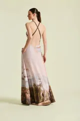 Vestido largo color rosado con estampa artística de caballos blancos en un paisaje campestre, escote en V pronunciado, tirantes finos con detalles animal print y bolsillos laterales.