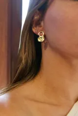 Aros tipo argolla pequeña con dije circular de superficie texturizada, confeccionados en bronce.