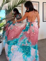 Vestido largo verde con diseño estampado tipo tie-dye y detalles dorados, de corte fluido, un solo hombro y diseño amplio.