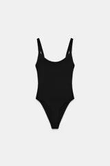 Body de cuello cuadrado con tirantes finos, confeccionado en tejido elástico con cierre inferior mediante botones a presión.