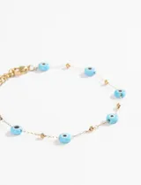Pulsera plateada de acero quirúrgico con dijes de cerámica celeste con forma de ojo turco.