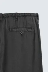 Pantalón de corte regular fit confeccionado en mezcla de algodón y lino. Presenta cintura elástica con cordón ajustable, cierre frontal con cremallera y botón, bolsillos laterales y bolsillo trasero de vivo con botón.