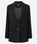 Blazer negro de corte sastrero, con solapas en el cuello, doble botonadura frontal y bolsillos falsos con solapa.