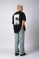 Remera negra de corte oversize con cuello redondo y estampa frontal pequeña con el texto 90's en color blanco.