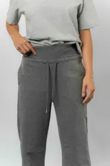 Pantalón blanco de silueta amplia y caída fluida, con cintura alta elastizada y lazo regulable con terminaciones metálicas.