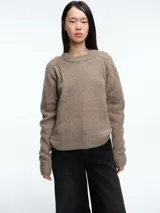 Sweater de tejido suave en tono beige melange, con cuello redondo, mangas largas y corte relajado.
