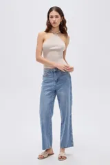 Pantalón de jean azul de corte recto y tiro medio, con detalles de estrellas bordadas a lo largo de los laterales externos de las piernas.