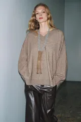 Jersey oversize color beige melange, confeccionado con lana, con cuello en V y manga larga.