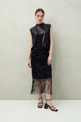 Falda larga negra de lentejuelas con terminación en flecos.