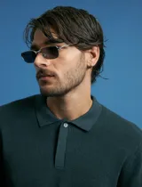 Remera de punto tipo polo con textura waffle, color verde petróleo, de manga larga y cuello con cierre de botones.