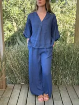 Blusa azul marino de lino, con cuello camisero que forma un escote en V, mangas cortas dobladas y calce holgado.