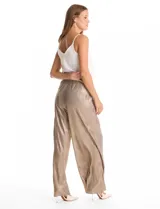 Pantalón wide leg de tiro alto con diseño plisado vertical y acabado metalizado en tono dorado. Presenta una cintura elástica fruncida con lazo de ajuste frontal y bolsillos laterales ocultos.