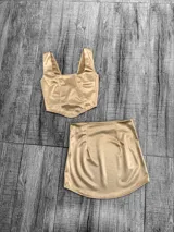 Conjunto de dos piezas confeccionado en tela satinada color azul vibrante. Incluye un top tipo corset con escote cuadrado y una minifalda ajustada de tiro alto.