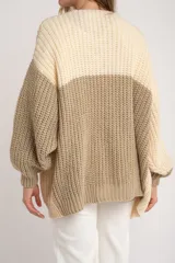 Cardigan de punto grueso con diseño color block en tonos beige, crema y verde oliva. Corte oversize y mangas largas.
