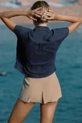 Camisa fluida oversize de lyocell color azul marino, con cuello solapa, manga corta tipo murciélago y cierre frontal con botones.