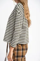 Remera de manga larga, corte al cuerpo, con cuello redondo. Presenta un patrón de rayas horizontales en color marrón óxido y azul marino.