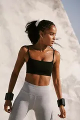 Top deportivo negro, tipo bralette, con escote cuadrado y tirantes finos. Presenta tejido acanalado y diseño sin costuras.