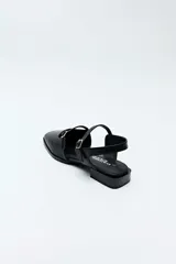 Sandalias chatitas Daniel Cassin color negro con textura símil reptil, punta cuadrada, taco bajo y doble tira delgada con hebilla metálica.
