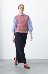 Chaleco tejido de algodón y acrílico, color rojo y blanco con patrón geométrico. Tiene cuello redondo y bordes acanalados en rojo.