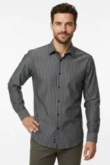Camisa de algodón de manga larga con diseño de rayas verticales en tonos gris y blanco, cuello camisero clásico y cierre frontal con botones.