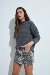 Sweater de punto gris con cuello a la base y diseño de trama geométrica en relieve. Presenta un calce relajado con mangas largas y puños tejidos.