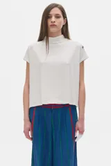 Blusa color crudo en rib de manga corta y cuello subido.