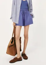 Short de lino color lila, con cintura elástica y cordón ajustable. Presenta un corte holgado y cómodo.