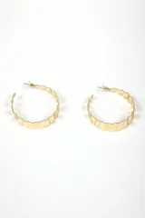 Par de aros argolla grandes de metal plateado con borde ondulado o festoneado.