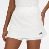 Falda de tenis blanca con short interior, confeccionada con tejido de secado rápido NB DRY. Cuenta con bolsillo para guardar pelotas de tenis y teléfono móvil.