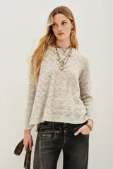 Sweater de punto con diseño calado geométrico, cuello redondo y mangas largas. Confeccionado en una mezcla de lana y alpaca, presenta una textura suave y ligera.