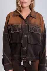 Campera de denim azul con calce boxy, cuello clásico, cierre con botones metálicos, mangas largas con puños abotonados, dos bolsillos frontales con solapa y parche con logo en el frente.