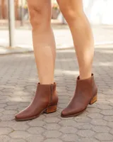 Bota alta de cuero y gamuza color marrón, con diseño 2 en 1 que incluye estribo desmontable, taco cuadrado y punta cuadrada.