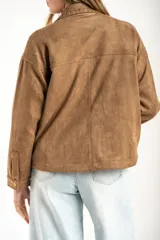 Sobrecamisa de gamuza sintética color camel, con corte oversize, cuello clásico con detalle de costura, cierre frontal con botones metálicos y mangas largas.