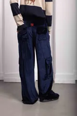 Pantalón cargo de terciopelo verde oscuro, de corte holgado, cintura elástica y bolsillos con solapa en la parte trasera. Cuenta con detalle de bordado rojo en la parte superior.