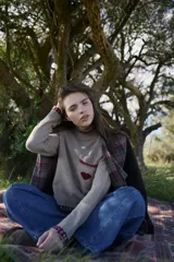 Chaqueta de lana en tono verde oliva con textura jaspeada, cuello mao y detalle de volado frontal. Presenta un corte entallado, bolsillos delanteros con solapa y cierre frontal con botones.