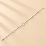 Pulsera de cadena fina en plata 925, con dije central en forma de silueta de niña y pequeñas esferas plateadas distribuidas a lo largo de la cadena.