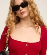 Blusa cropped de punto roja con escote cuadrado, mangas largas y botones dorados.