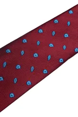 Set compuesto por una corbata y un pañuelo de bolsillo a juego, ambos en color bordó con un estampado geométrico sutil en tono oscuro.