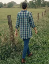 Camisa de manga larga con estampado de cuadros en tonos verde, azul marino y amarillo. Presenta un canesú bordado en la parte superior del pecho y hombros con diseño geométrico en tonos verdes y blancos.