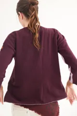 Buzo de escote en V y manga larga, confeccionado en lana lambswool. Presenta un diseño básico con detalle de raya en contratono en una de las mangas, puños y ruedo en color contrastante, y pin metálico de la marca aplicado en la manga.