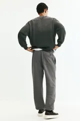 Pantalón deportivo de felpa gris oscuro, con interior cepillado suave. Presenta cintura elástica con cordón de ajuste, bolsillos laterales y puños acanalados en los tobillos. Corte relajado.