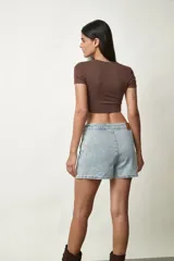 Minifalda de denim celeste con diseño de corte recto, costuras frontales destacadas y pequeña abertura lateral en el dobladillo.