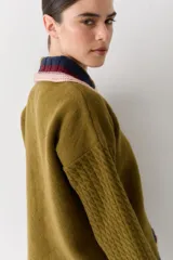 Buzo de lana tipo polo con cuello y cartera de botones en colores contrastantes. Presenta mangas con textura de ochos y puños y ruedo con terminaciones en franjas de colores.