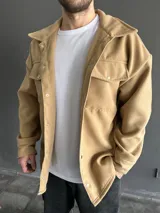 Chaqueta tipo camisa de paño color camel con cuello clásico, cierre frontal con botones a presión y bolsillos de parche con solapa en el pecho.