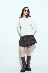 Sweater negro de tejido texturizado con líneas horizontales en relieve, de silueta levemente holgada y hombros caídos.