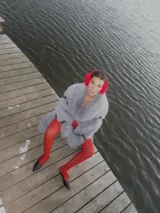 Chaqueta gris de piel sintética con cuello solapa y cierre cruzado con botones a presión.