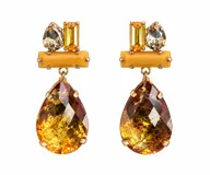 Caravanas colgantes doradas con estructura geométrica superior decorada con cristales facetados y una gran piedra en forma de gota en tono ámbar.