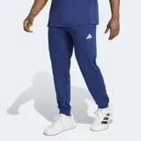 Pantalón de entrenamiento Adidas Essentials Feelready, color azul, con ajuste clásico, bolsillos con cierre, cordón de ajuste en la cintura y el logo de la marca en blanco en la pierna izquierda. Incorpora tecnología Climacool para regular la temperatura y expulsar la humedad.